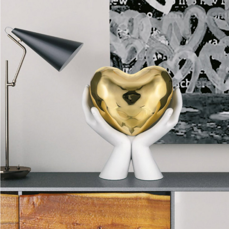 Scultura moderna grande con mani che stringono un cuore