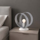 Lampada da comodino in metallo con struttura ad anelli e lampadina a vista