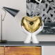 Scultura moderna con mani che stringono un cuore piccolo
