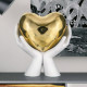 Scultura moderna con mani che stringono un cuore piccolo